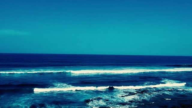 Aerial footage filmed with a drone overlooking the beach and sea of crashing waves with a deep blue ocean on the Bluff in Africa southern hemisphere.