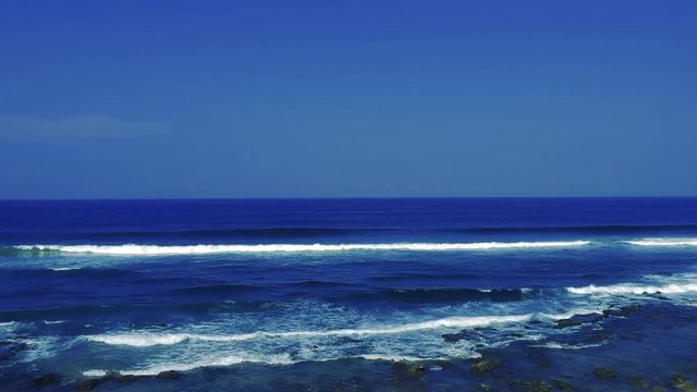 Aerial footage filmed with a drone overlooking the beach and sea of crashing waves with a deep blue ocean on the Bluff in Africa southern hemisphere.