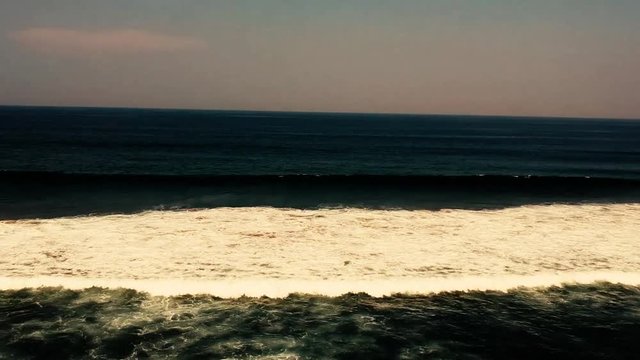 Aerial footage filmed with a drone overlooking the beach and sea of crashing waves with a deep blue ocean on the Bluff in Africa southern hemisphere.