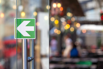 Glass door with an arrow in a restaurant