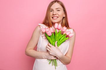 Happy girl in summer dress holding a bouquet of flowers in hand