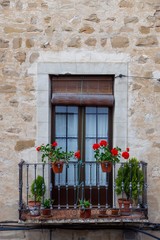 Fototapeta na wymiar balcony decorated with red geraniums in a typical andalusian old house