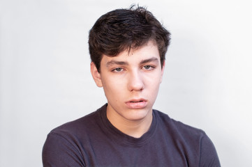 Fototapeta premium The young boy is very sleepy because he is tired of studying at the school looking forward to the holidays. He feels bad because he has a headache