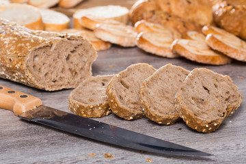 slices of wheaten bread and knife on wooden surface