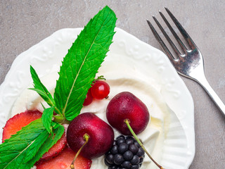 Meringue dessert Pavlova cake with fresh berries on a stone background, sackcloth decoration