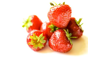 Red strawberries heap on white background view. Selective soft focus. Text copy space.