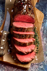 Roast beef from tenderloin A large piece is cut into pieces. A large portion of meat served on a...