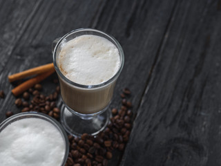 Cappuccino or mocha coffee on a dark wooden table with copyspace