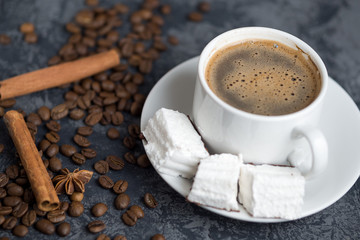 white Cup of Italian coffee with white marshmallow on dark table with copyspace