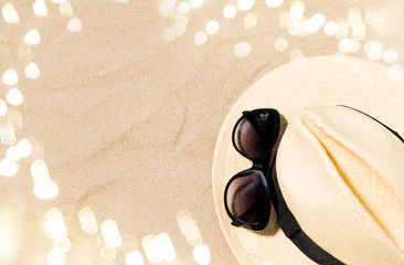 summer holidays and vacation concept - straw hat and sunglasses on beach sand