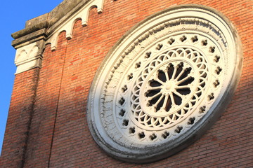 Fototapeta na wymiar round white window on red brick wall in italian architecture