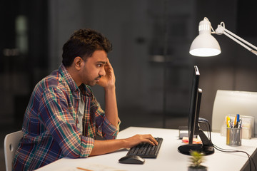 deadline, technology and people concept - stressed creative man with computer working at night...