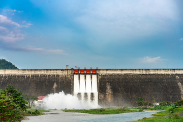 Amazing and beautiful water release at spillway or overflows at big dam with blue sky and cloud...