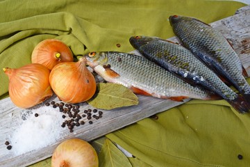 Freshly caught fish on a wooden Board and onions with spices.