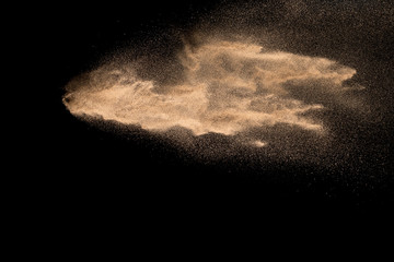 Plakat Abstract sand cloud. Golden colored sand splash agianst dark background.