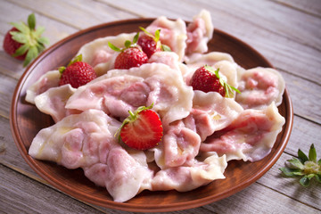 Dumplings, filled with strawberries. Varenyky, vareniki, pierogi, pyrohy. Diet vegetarian food