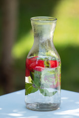strawberries in jar with mint leaves and water