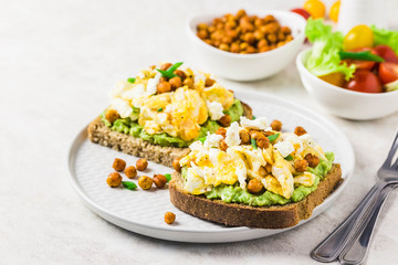 Scrambled eggs avocado feta chickpeas breakfast sandwiches. Selective focus, space for text.
