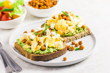 Scrambled eggs avocado feta chickpeas breakfast sandwiches. Selective focus, space for text.