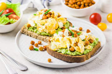 Scrambled eggs avocado feta chickpeas breakfast sandwiches. Selective focus, space for text.