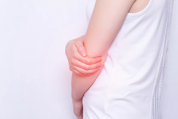 young girl holding her elbow joint, pain and inflammation in the elbow, white background, close-up, medical, copy space