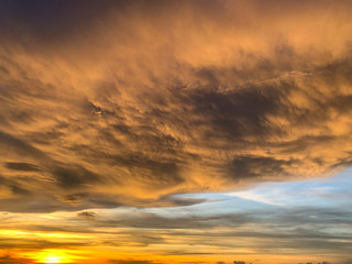 Dramatic sky with clouds on gold and red colour. Abstract of Storm cloudy is coming during Sunset over the sky.