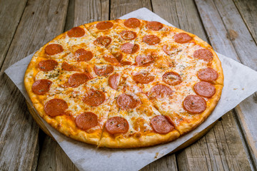 Pepperoni pizza on plate on wooden background