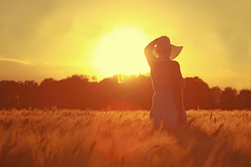Frau im Kornfeld beim Sonnenuntergang
