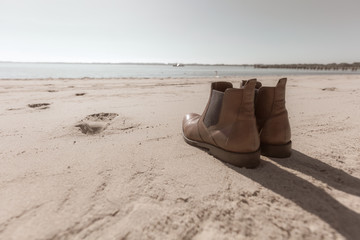 Fototapeta na wymiar a pair of shoes standing on the beach