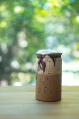 Iced mocha in clear plastic tin.