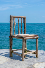 Wooden chair in empty cafe next to sea water in tropical beach . Island Koh Phangan, Thailand
