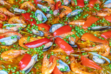 Spanish seafood paella in fry pan with mussels, shrimps and vegetables. Seafood paella background, closeup, traditional spanish rice dish