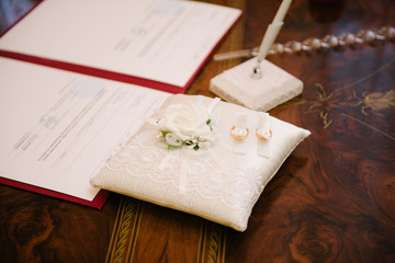 Wedding rings lie on a cushion for wedding rings close up