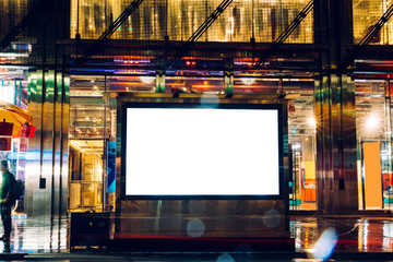 Billboard in rainy night with blank copy space screen for advertising or promotional publicity content, empty mock up Lightbox for information, blank display in urban street with city lights