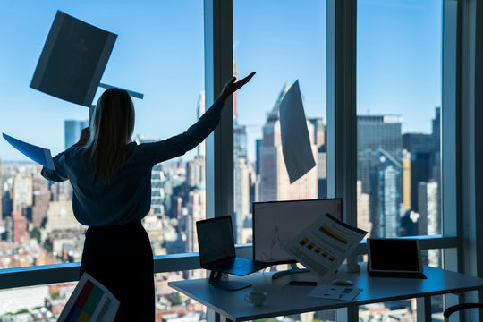 Woman Tossing Papers Up In Office