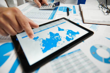 Businessman working and calculating, reads and writes reports. Using tablet pc. Office employee,...