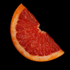 fresh red slice of grapefruit isolated on black background