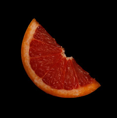 fresh red slice of grapefruit isolated on black background