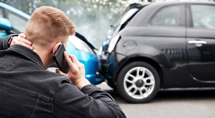 Young Male Motorist Involved In Car Accident Calling Insurance Company Or Recovery Service - obrazy, fototapety, plakaty