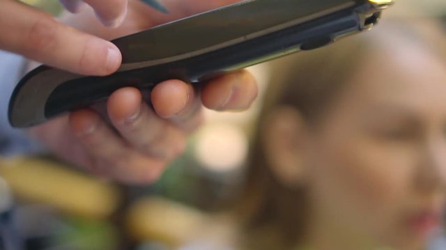 Closeup video waiter takes the order with mobile terminal, slow motion