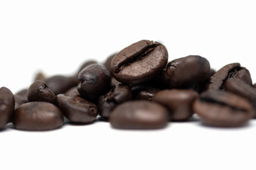 Roasted coffee beans isolated on white background. Close-up image.