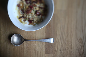 spoon near bowl of muesli with yogurt and nuts