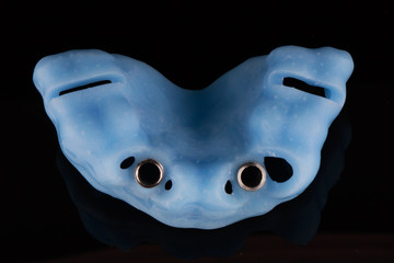 surgical template for the implantation of two implants, shot from above on a black background