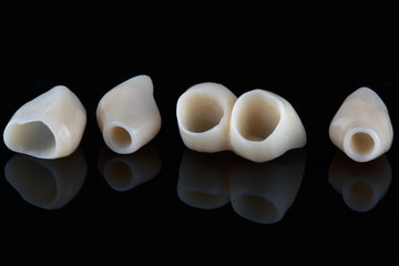 dental crowns for the front teeth of the upper jaw, shot on black glass with reflection © Dental Pro Content