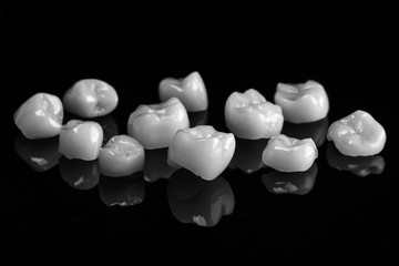 ceramic crowns on a black mirror with reflection, made in black and white style