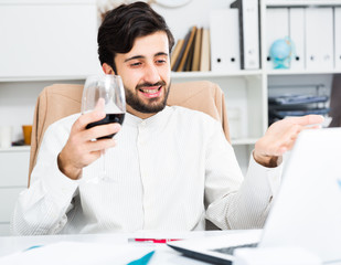 Man with wine having video chat