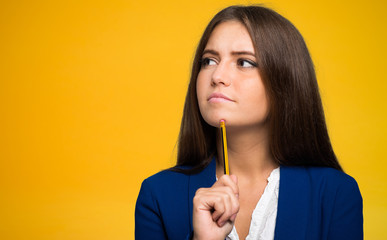 Young woman having an idea on a yellow background
