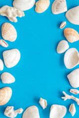 Summer at the sea design for blog with shells frame on blue background top view copy space