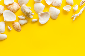 Summer at the sea design for blog with shells on yellow background top view copy space