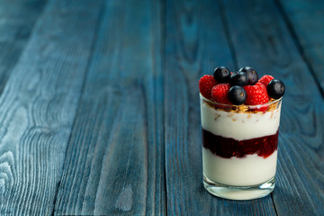 The healthy breakfast of yogurt with muesli, granola and fresh fruits rasberry and blueberry